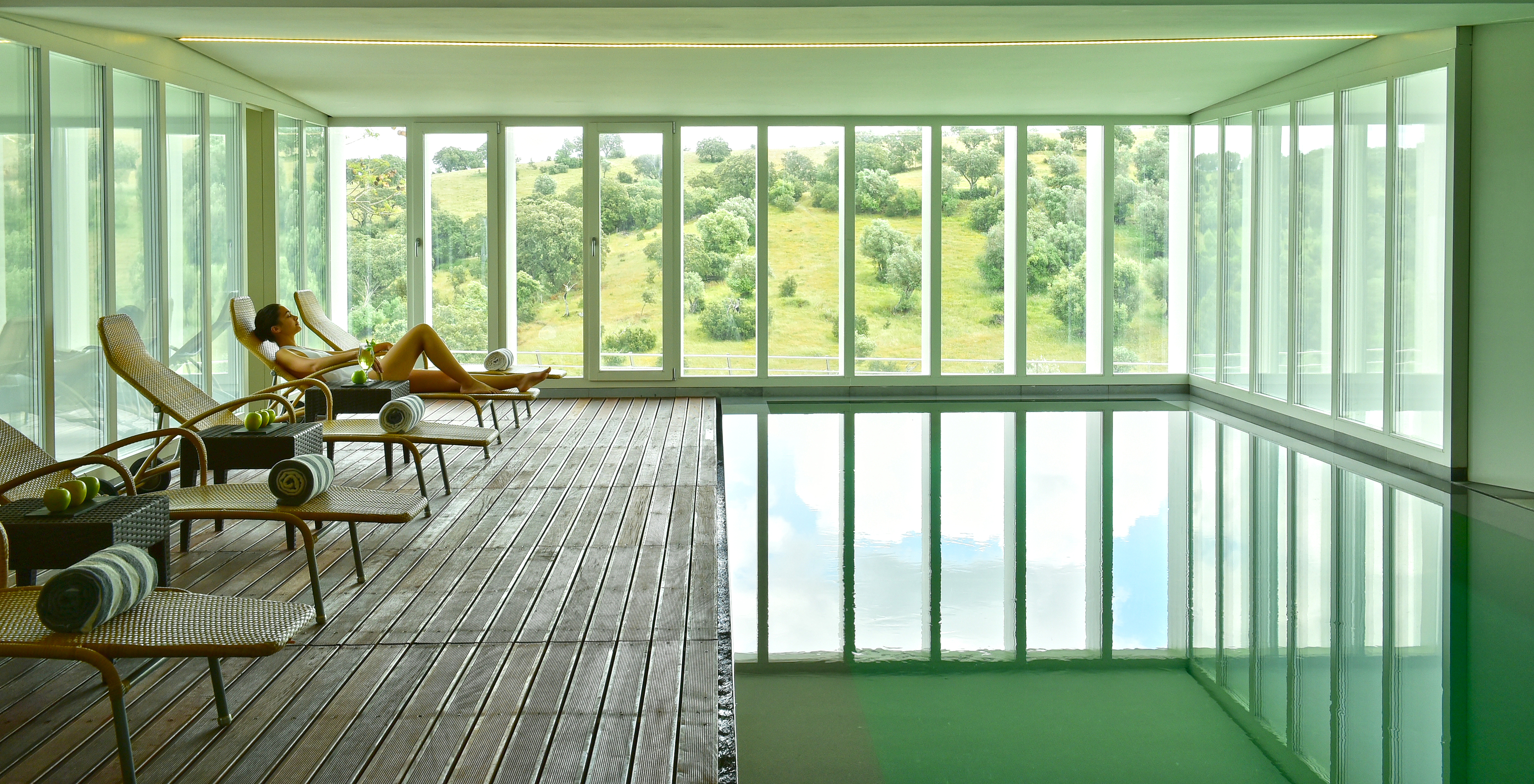 Piscine intérieure de la Pousada Convento Arraiolos, avec chaises longues dans une ambiance relaxante avec vue sur le champ