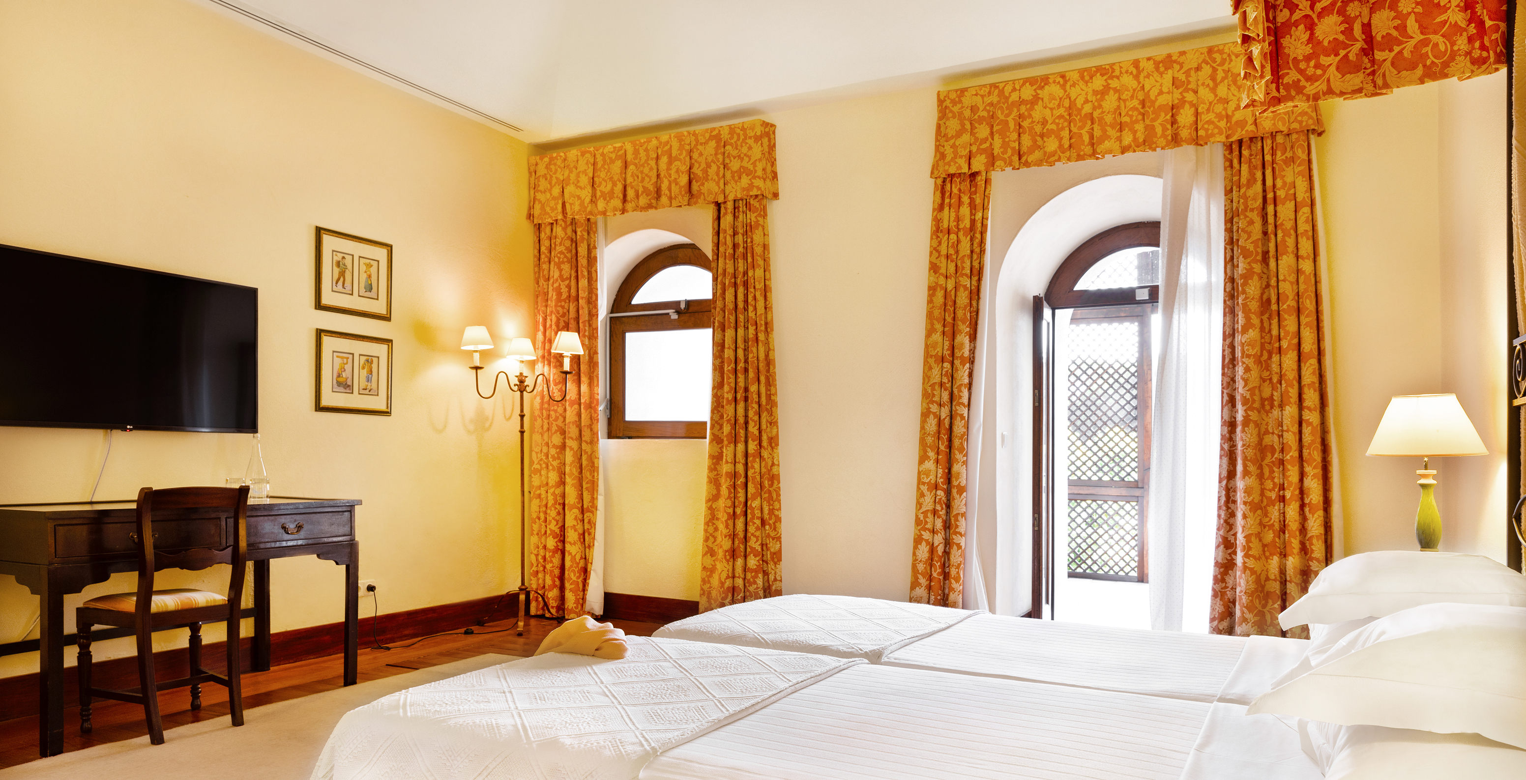 Le Chambre Famille de la Pousada Convento Vila Viçosa a une fenêtre et une porte vers une terrasse à côté du lit