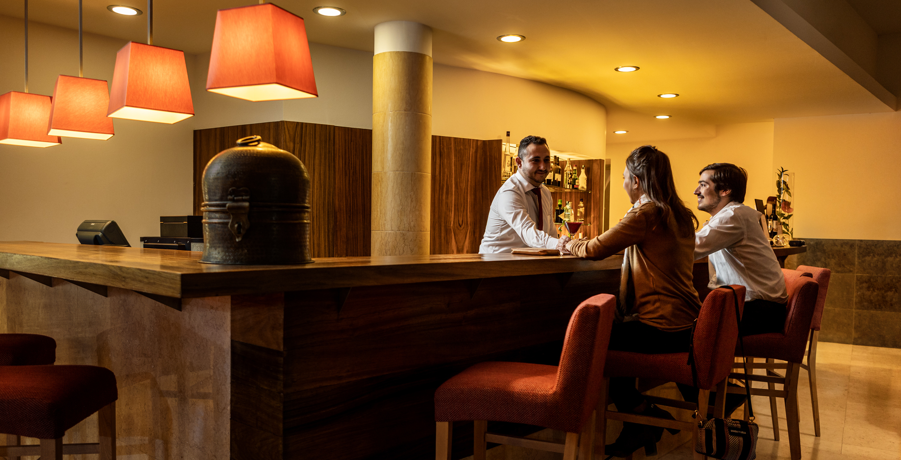 Le bar Pousada Convento Tavira, à l'Hôtel dans le Centre Historique de Tavira, a un couple assis, servi des cocktails