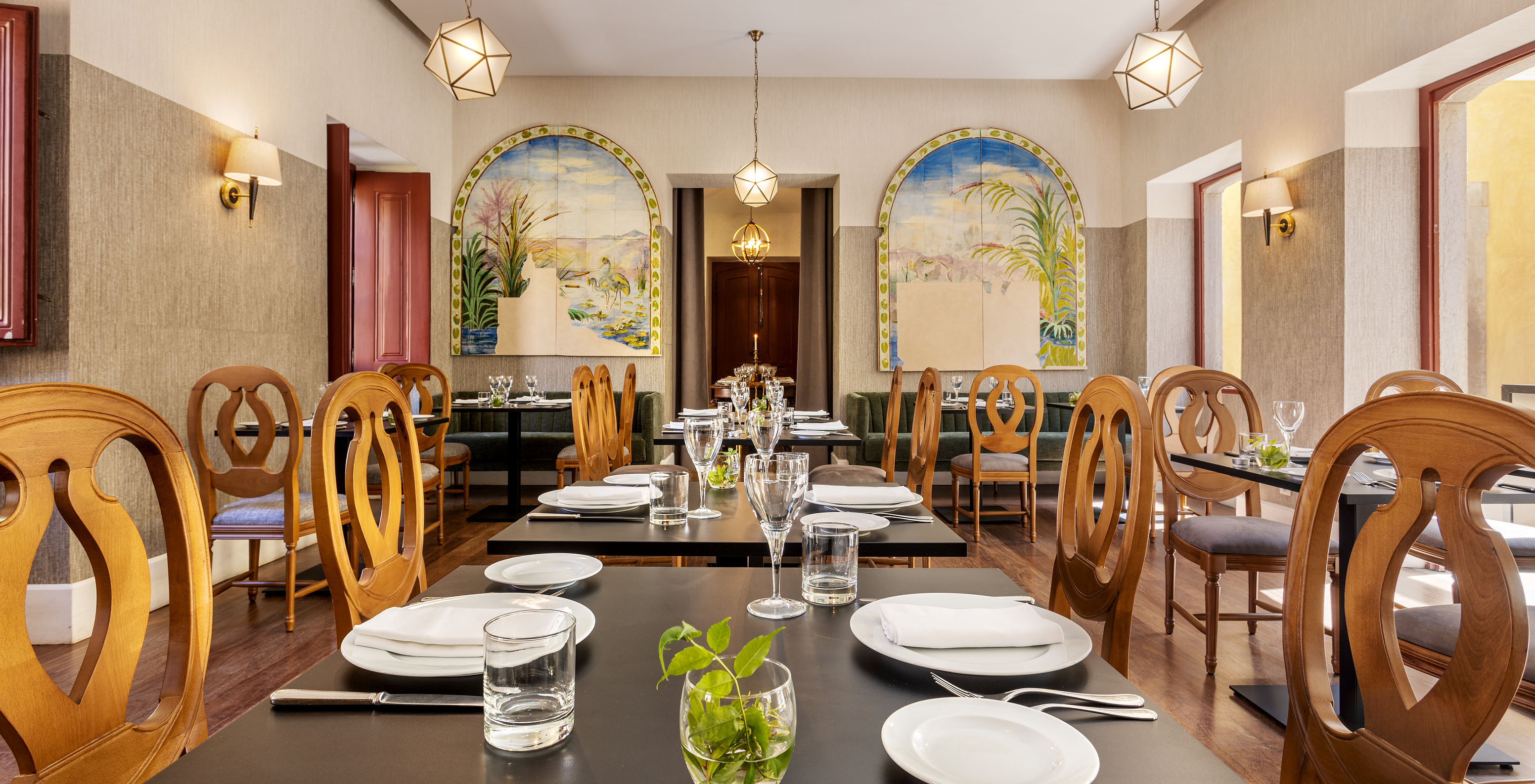 Le restaurant Visconde, à l'Hôtel Historique à Faro, a une grande salle avec plusieurs tables et des azulejos au mur