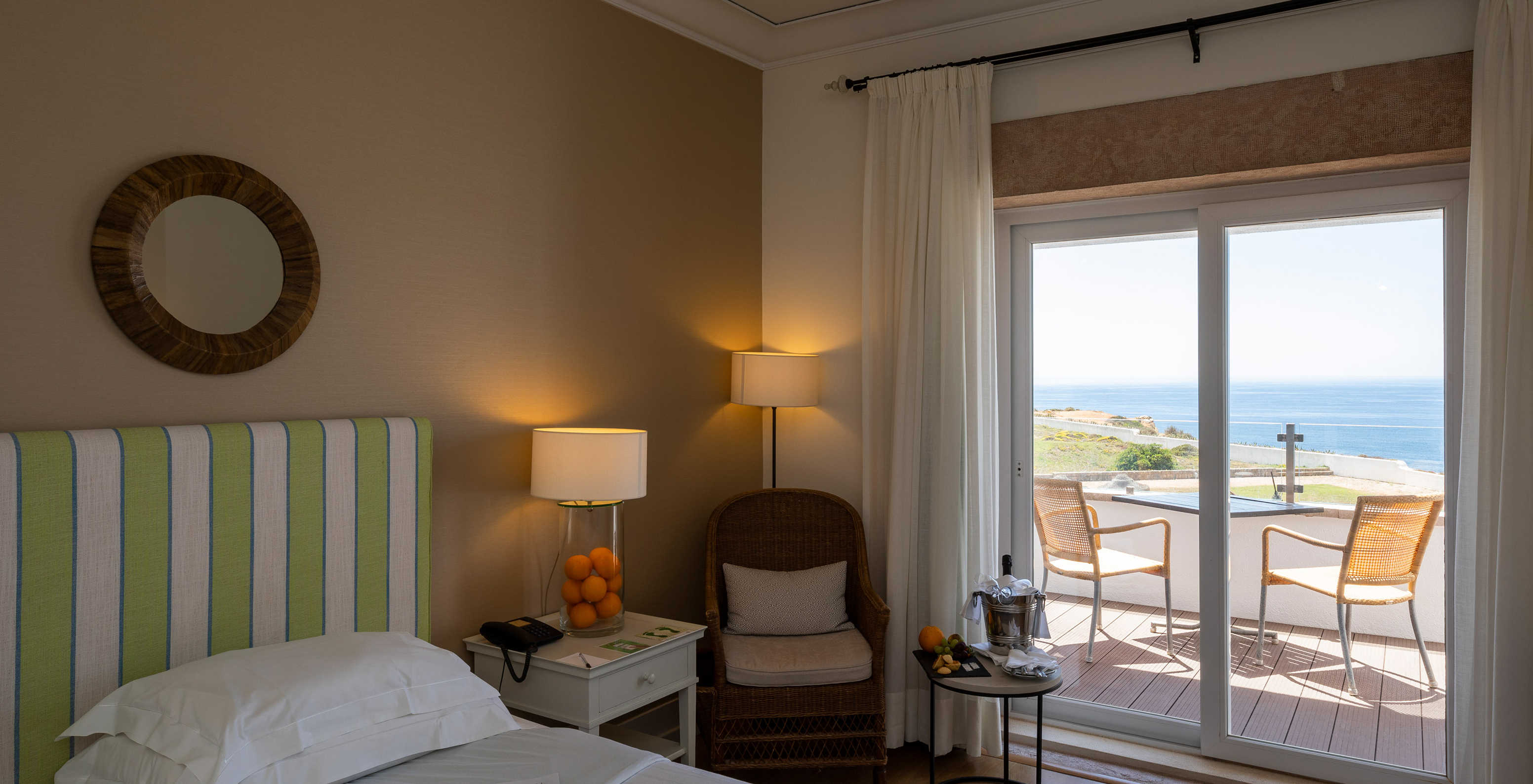 La Chambre Supérieure de la Pousada Sagres a un balcon avec table et chaises, un lit avec tête de lit rayée et snacks