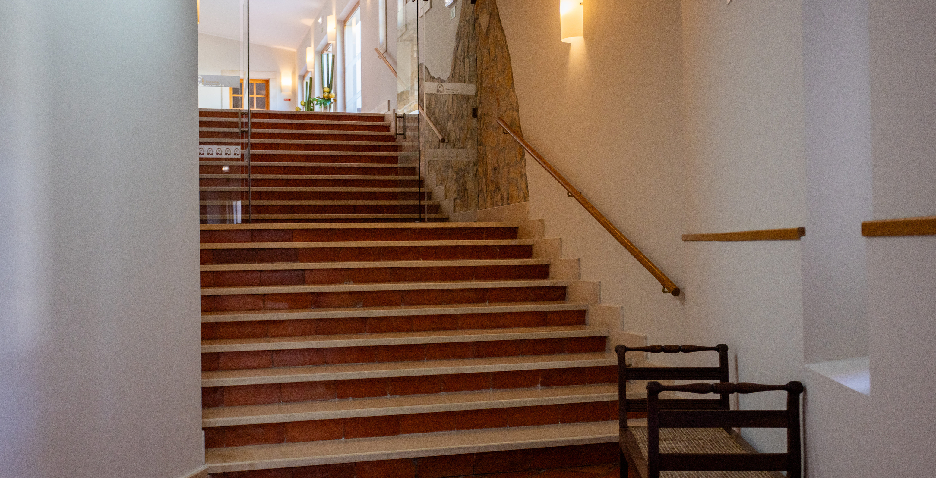 Escaliers menant à l'entrée de la Pousada Ourém, un hôtel historique près de Fátima, avec des portes en verre