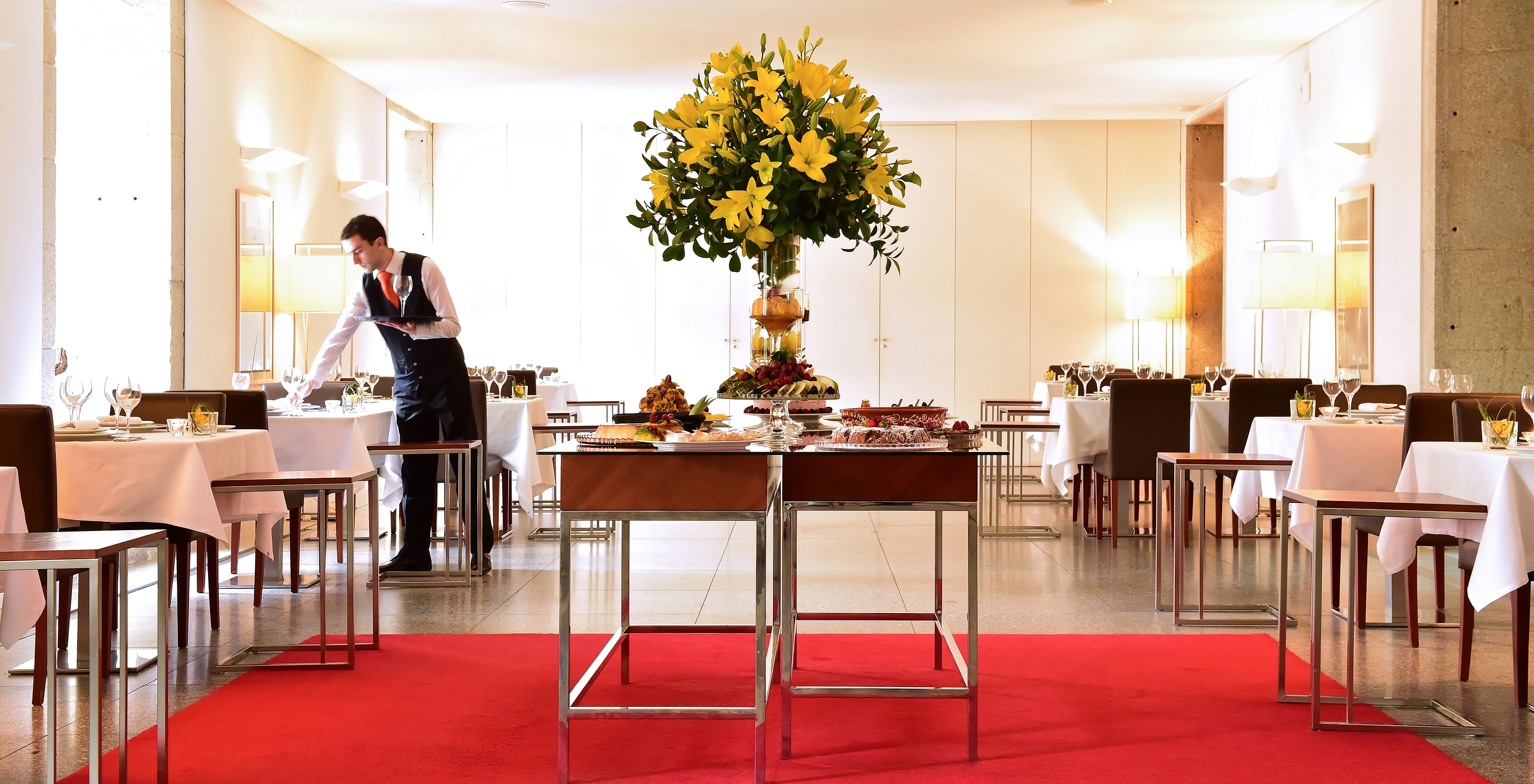 Le restaurant Viriato, à l'Hôtel Historique à Viseu, a un espace confortable avec des chaises et une variété de plats