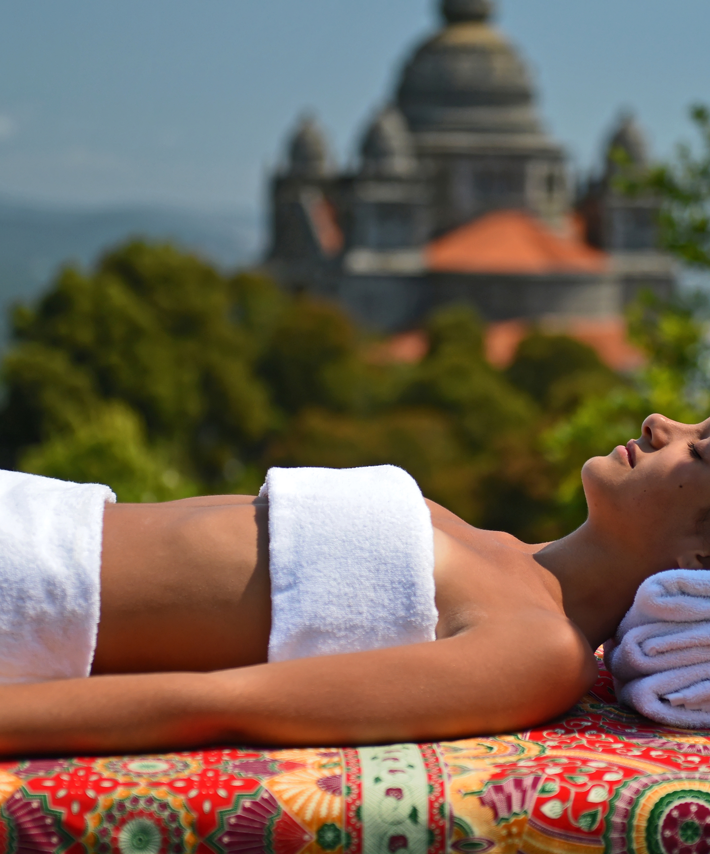 Femme allongée avec deux serviettes sur une table de massage dans un hôtel au Monte de Santa Luzia