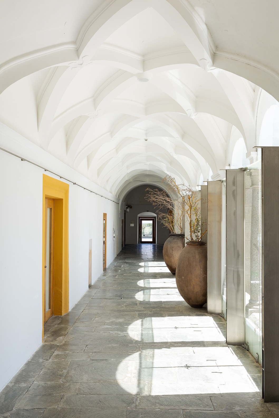 Gang met gewelfde plafonds van Pousada Convento Arraiolos met licht dat door de cloisters naar binnen komt