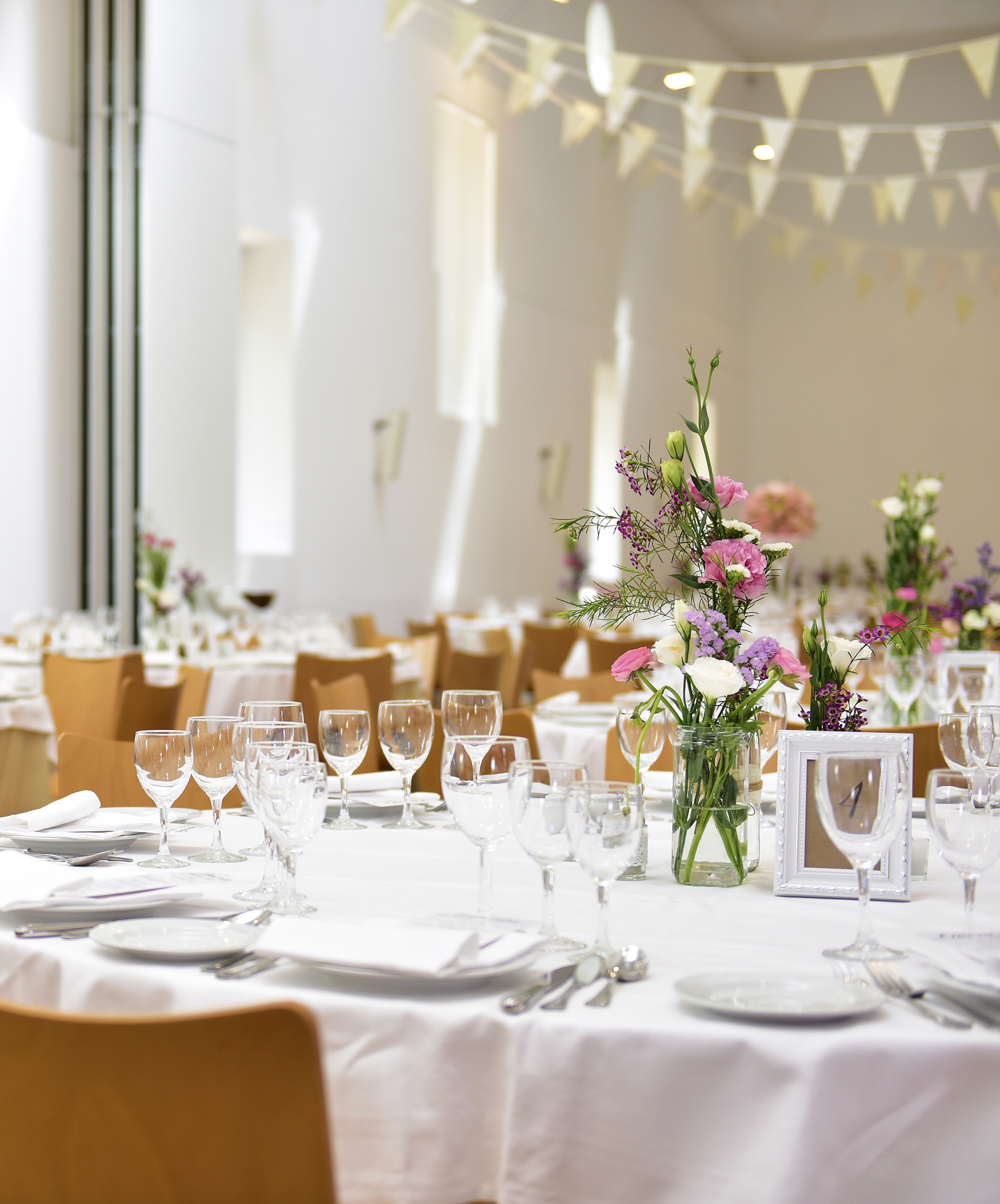 Restaurant van de Pousada Palácio Estoi heeft verschillende ronde tafels en een bloemenarrangement