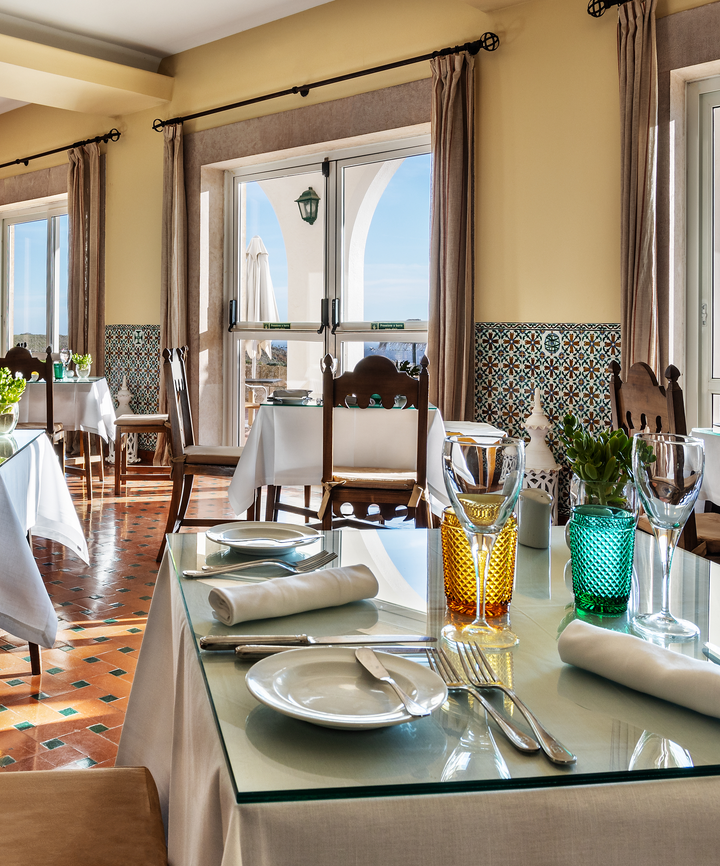 De Pousada Sagres heeft een restaurant met verschillende tafels en ramen met uitzicht op de zee op 5 minuten van het strand