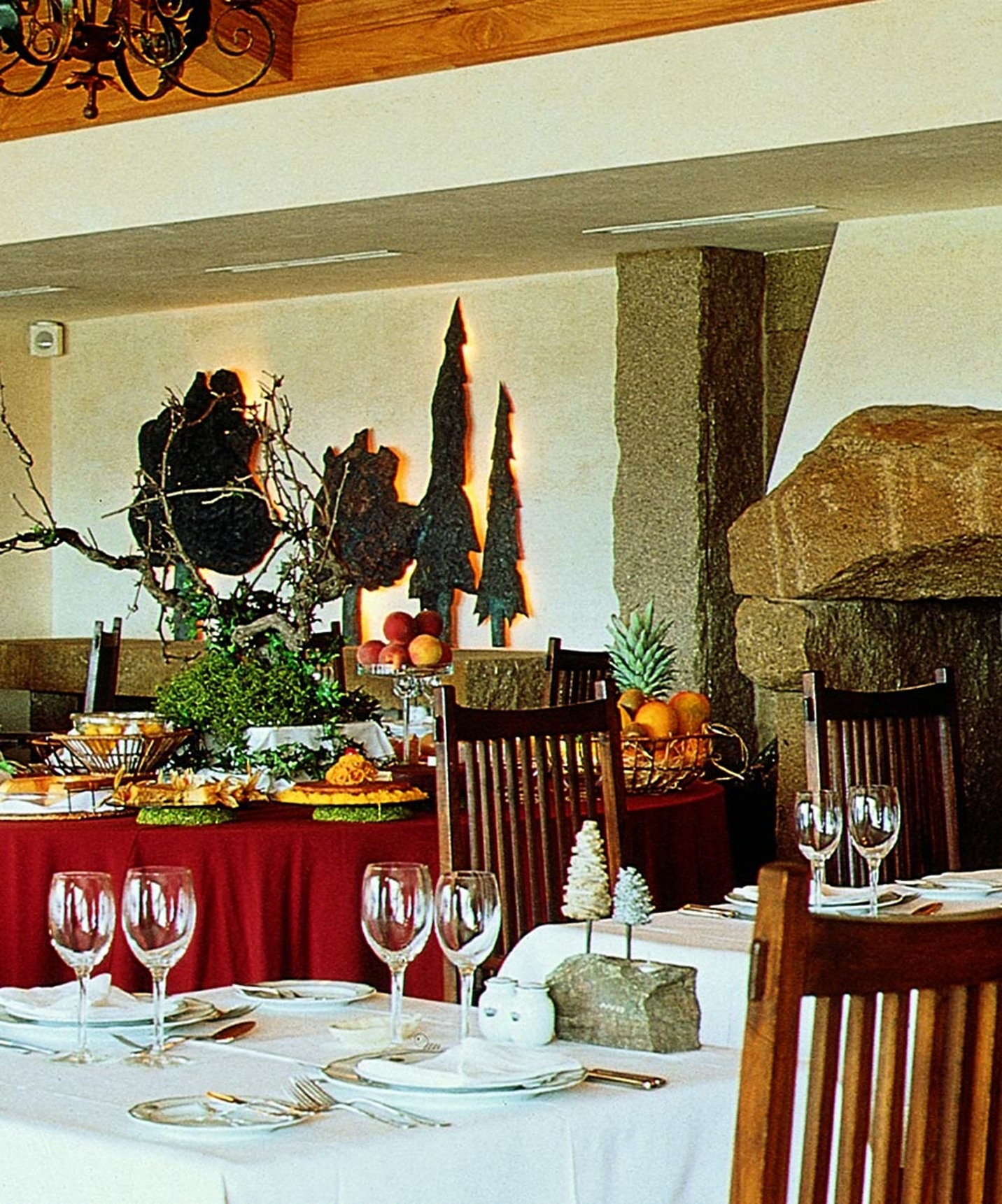 Restaurant van de Pousada Convento Belmonte, met tafels klaargezet voor maaltijden en een buffet met zoetigheden en fruit