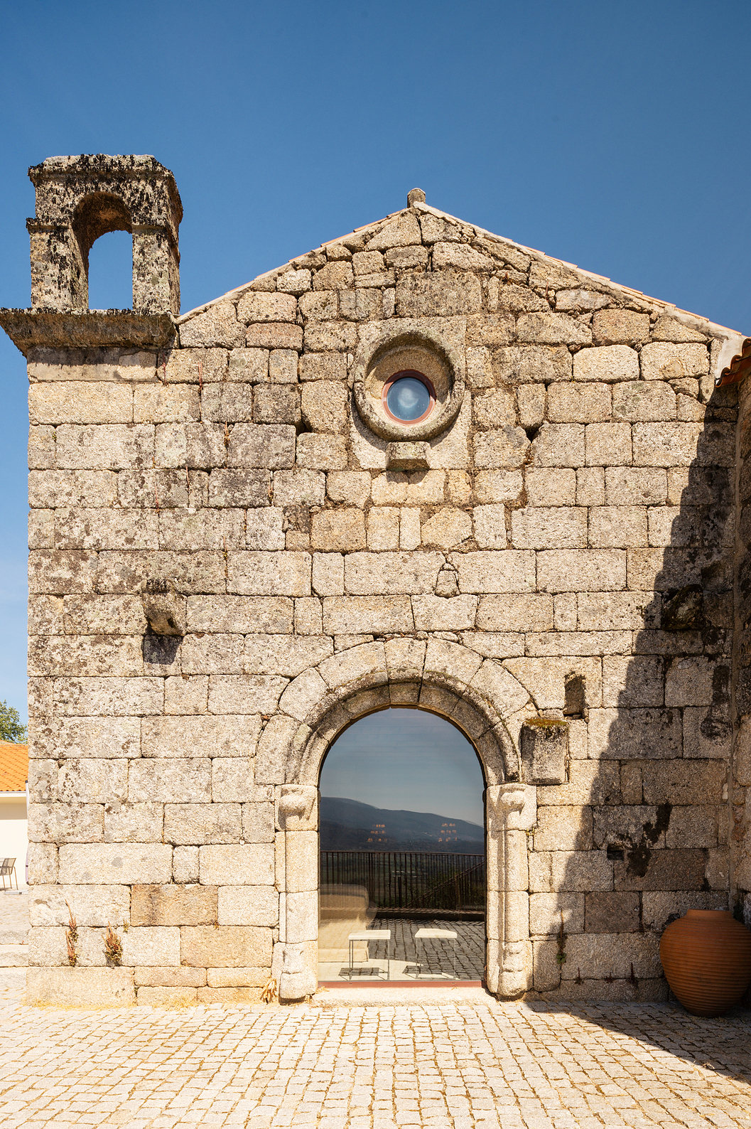 Kerk in Belmonte, in het centrum van Portugal, gebouwd van steen met een deur die het uitzicht op de kerk weerspiegelt