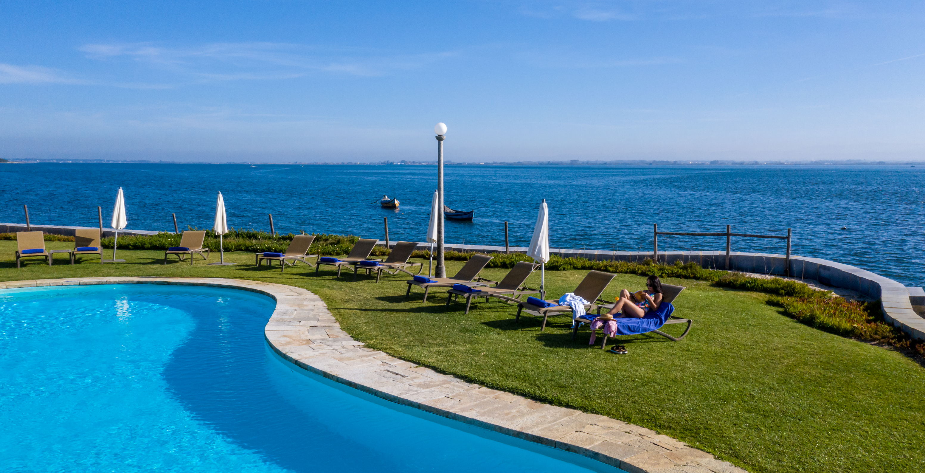 Uitzicht op het buitenzwembad van het charmante hotel in Aveiro, met panoramisch uitzicht op de ria