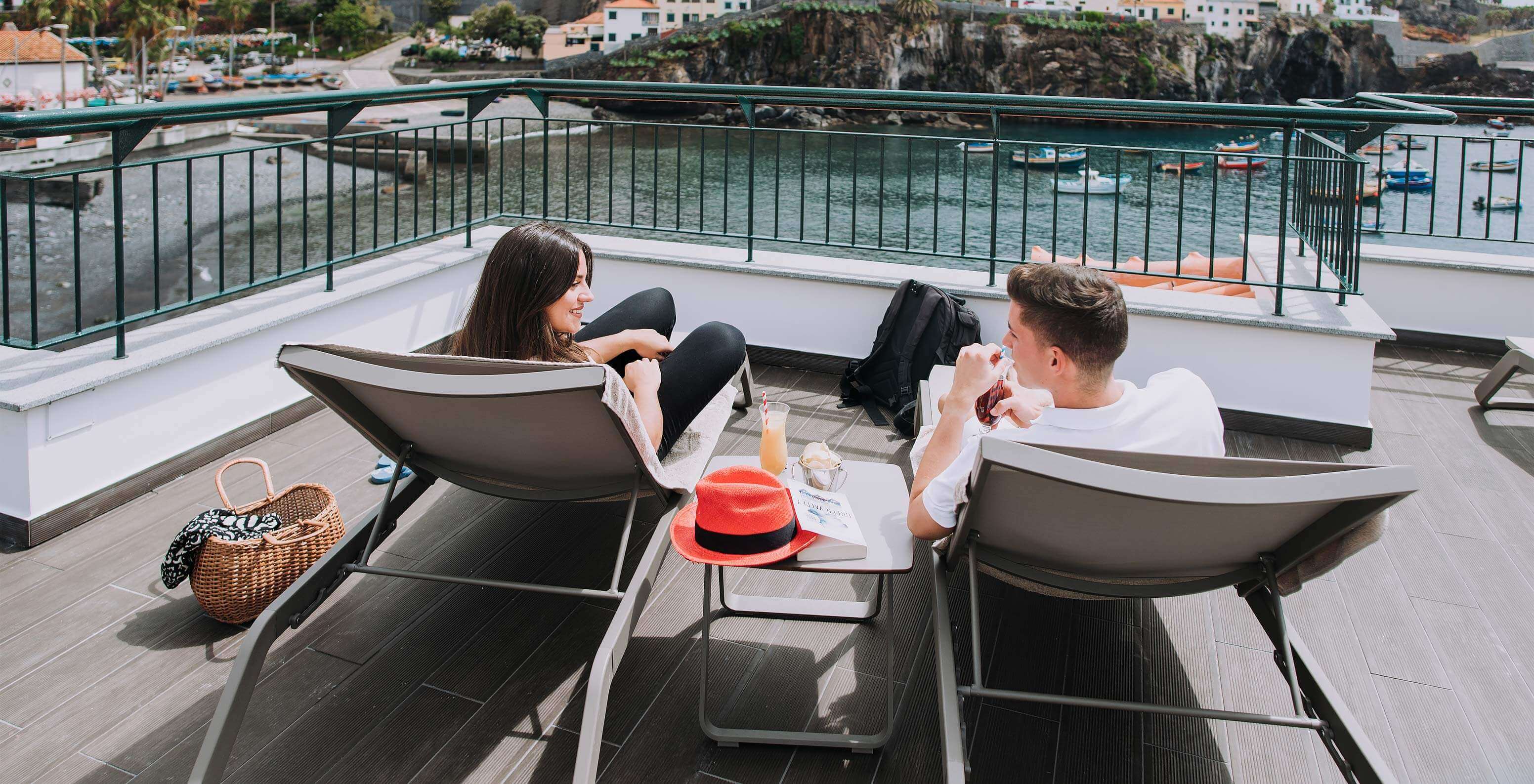 Terras met ligstoelen van Pestana Churchill Bay met uitzicht op de baai van Câmara de Lobos