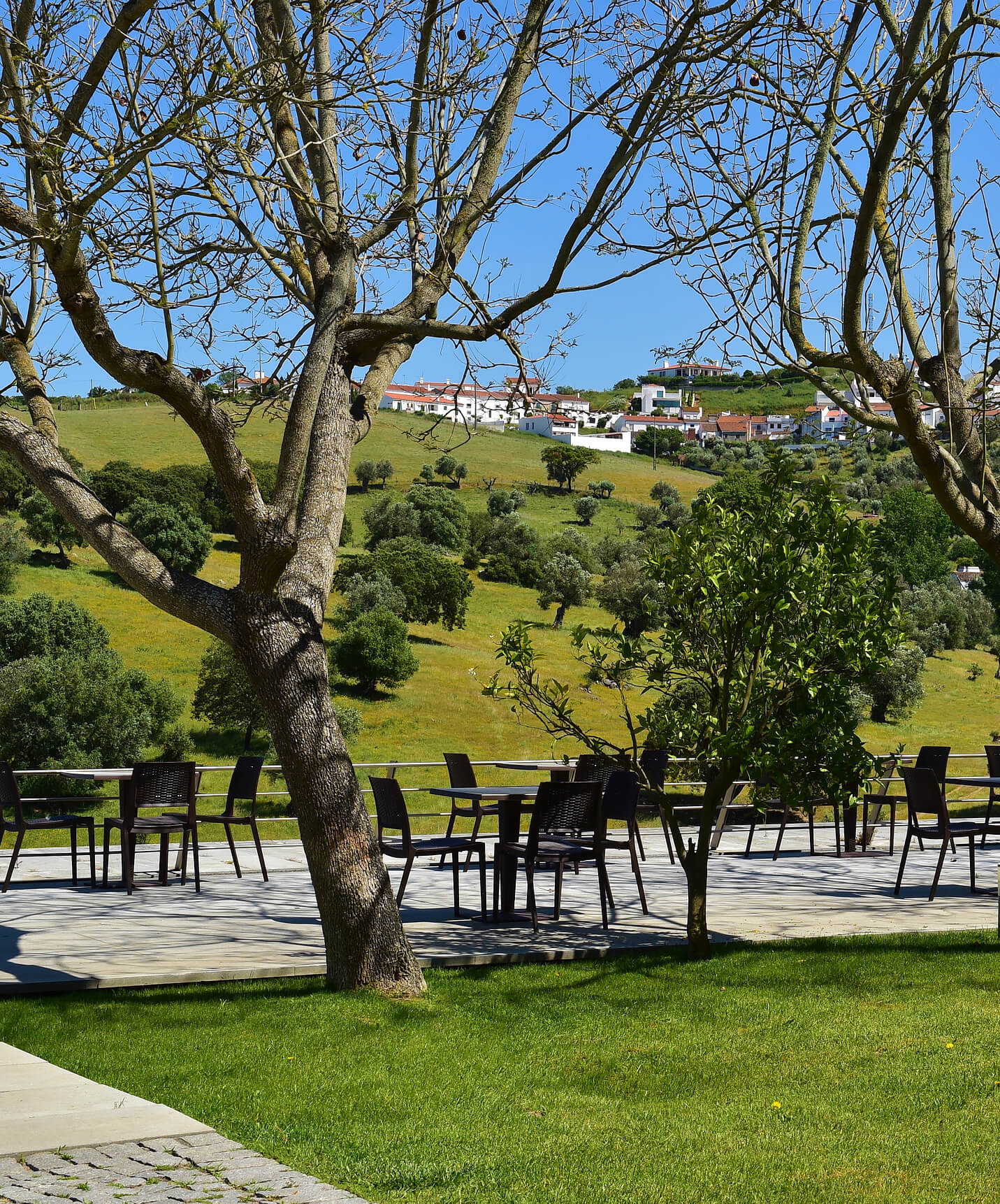 Jardim com mesas ao ar livre num dia de sol, na Pousada Convento Arraiolos, Hotel em Arraiolos no Alentejo