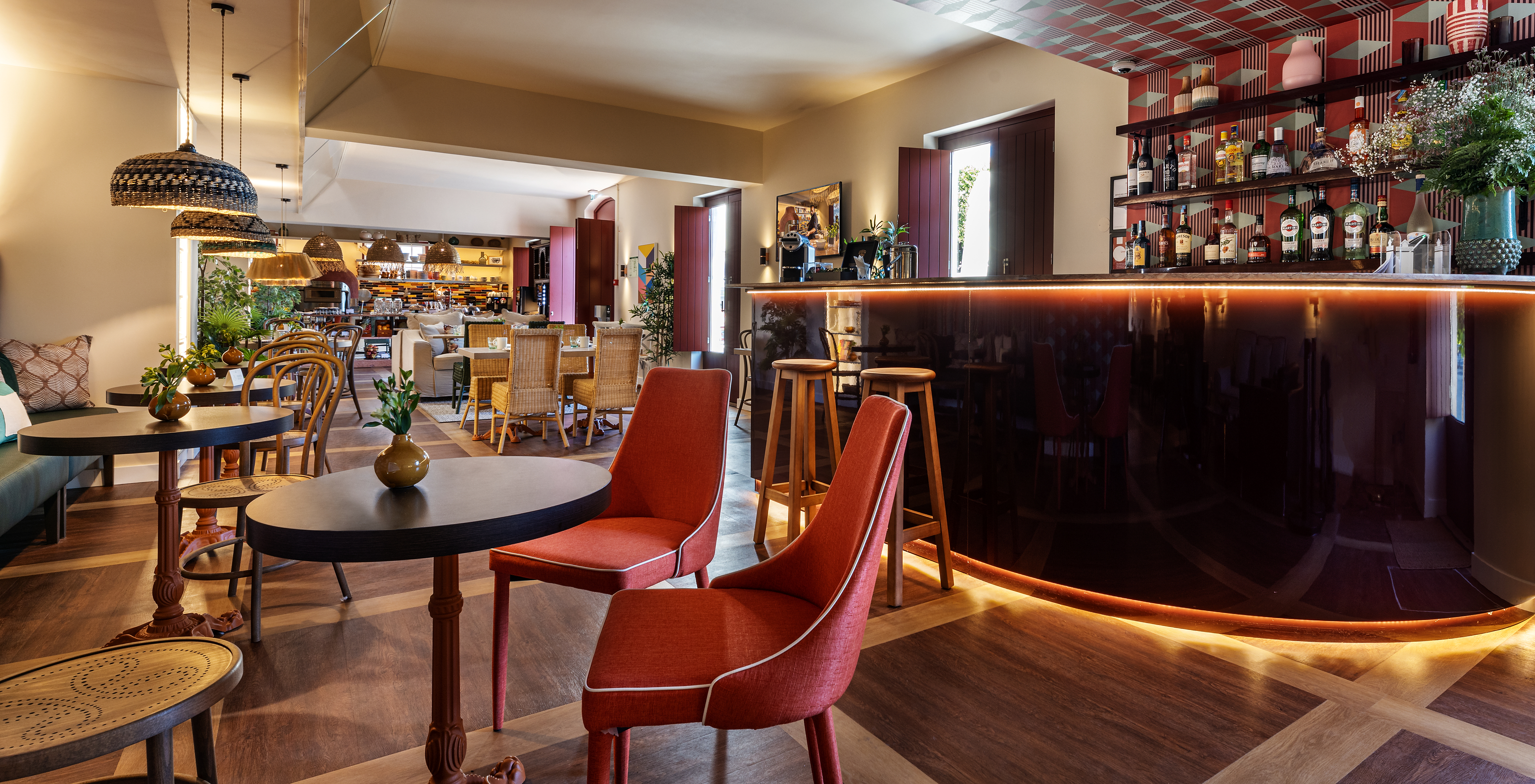 Restaurante com decoração moderna em tons de vermelho e castanho e um bar em Hotel Histórico Perto da Praia