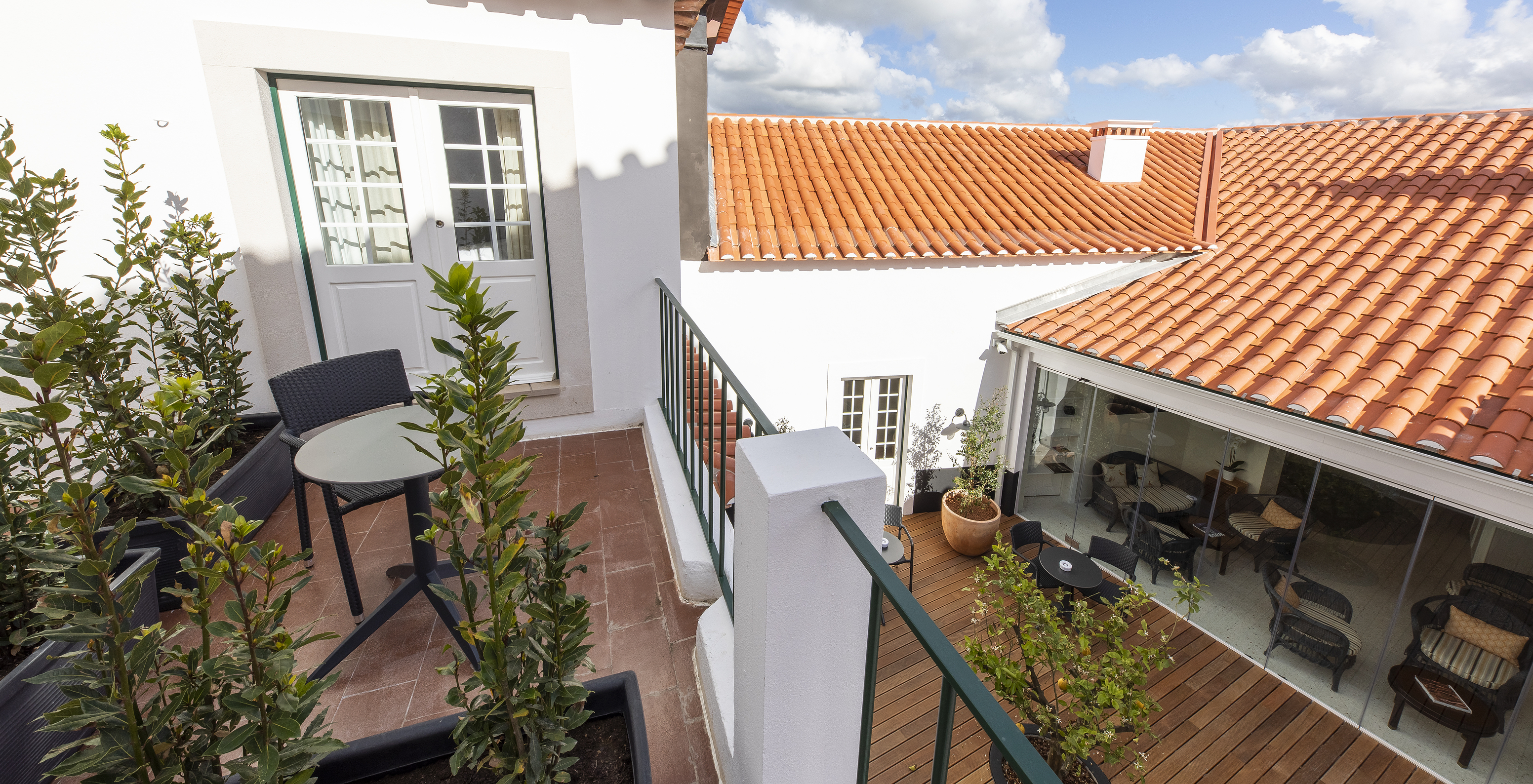 Varanda da Pousada Vila Óbidos, Bed and Breakfast em Óbidos, com uma mesa e cadeira, plantas e vista para o pátio exterior