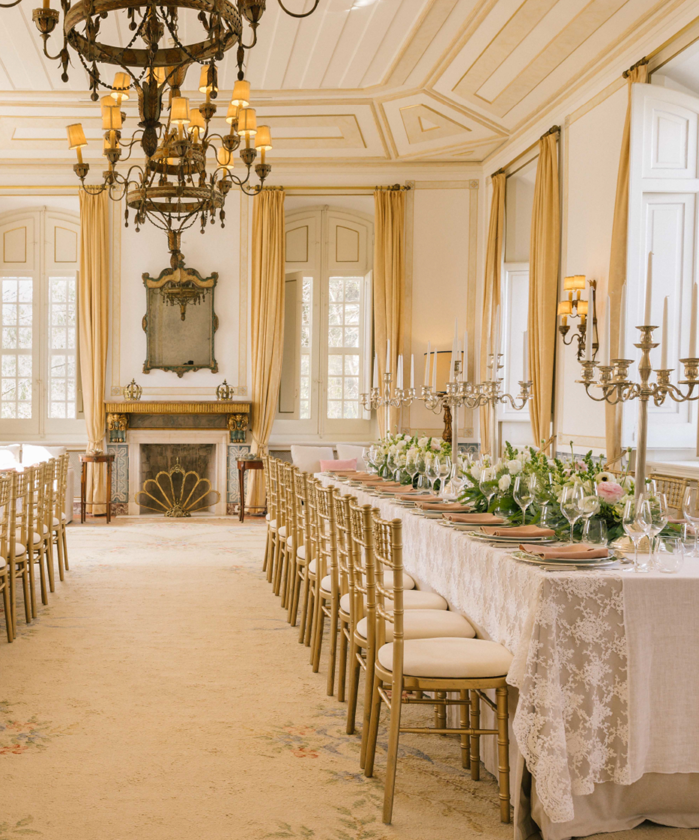 Espaço para eventos, num hotel histórico em Queluz, com duas mesas compridas e cadeiras, arranjos de mesas e copos